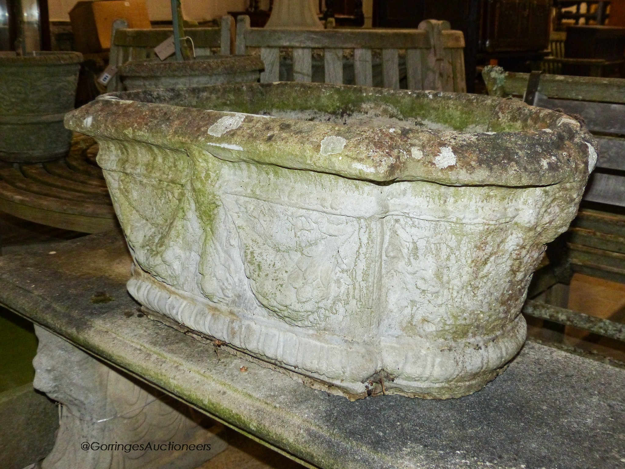 A pair of reconstituted stone shaped oval planters with swag decoration, width 80cm, height 42cm